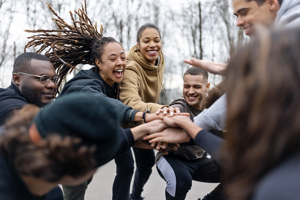 Teambuilding Teambuilding von einer Gruppe die die Hände zusammenlegen.