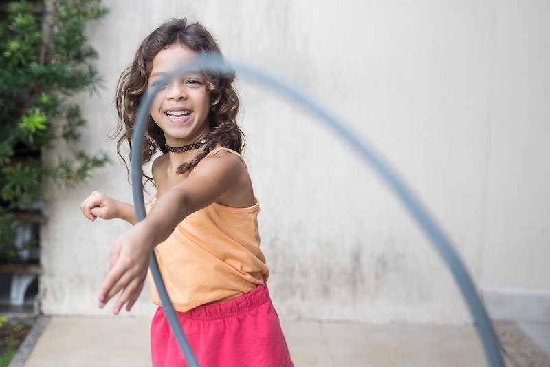 Hula-Hoop-Training Kind Ein Kind trainiert mit einem Hula-Hoop-Reifen