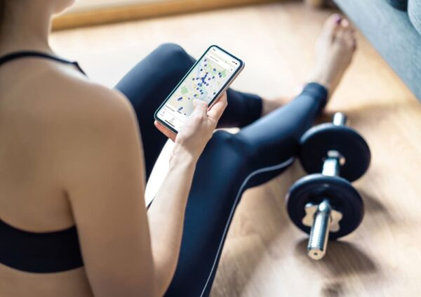 deutschlandweit-headerbild Eine Frau schaut beim Sport machen auf die Hansefit App-Studiosuche