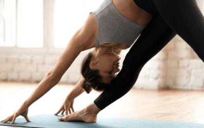 yoga Eine Frau macht auf einer Matte Yoga und dehnt ihr Bein