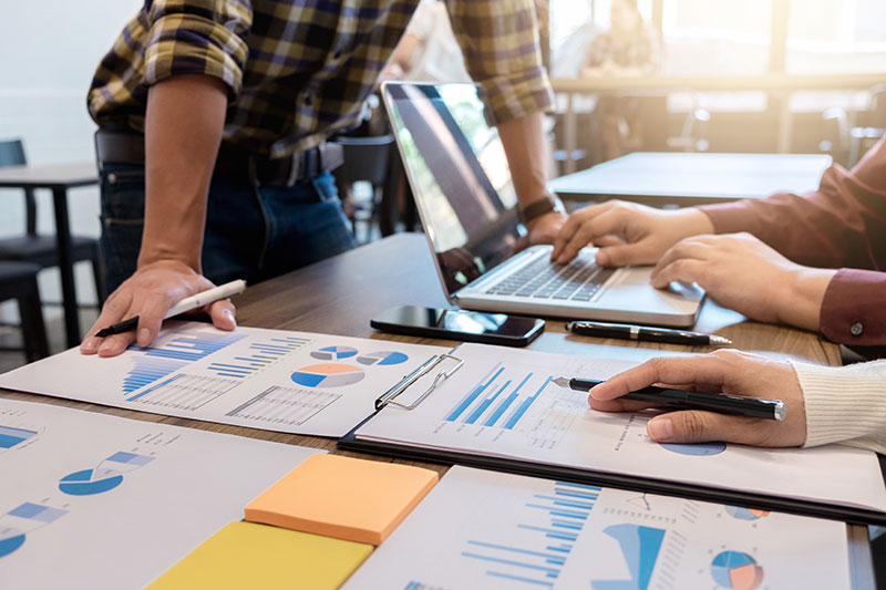fitbase_ueber_uns_forschung Detailaufnahme von Personen, die an Statistiken arbeiten