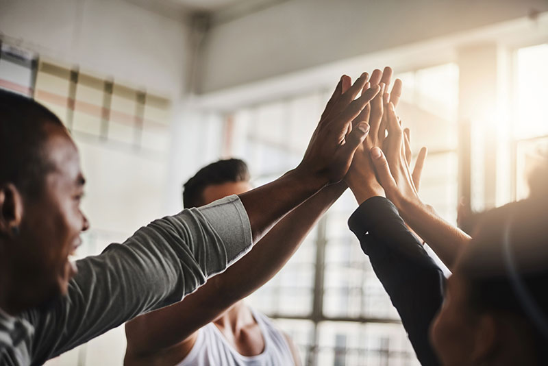 fitbase_ueber_uns_leitbild Ein Team gibt sich High Five
