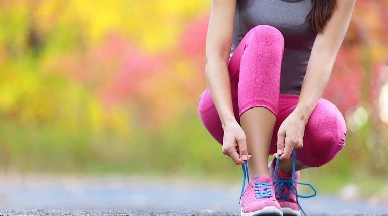 Person bindet Schuhe zu Person bindet Schuhe zu