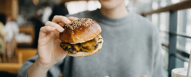 Frau hat einen Burger in der Hand