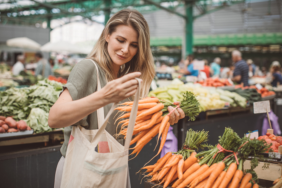 Frau kauft auf einem Markt ein Frau kauft auf einem Markt Gemüse ein