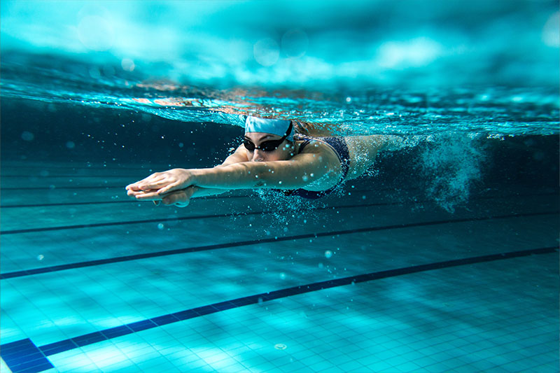 hansefit_firmenfitness_sportarten_03 Eine Schwimmerin taucht ins Wasser ein