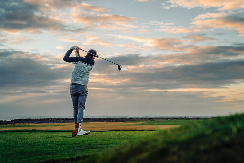 hansefit_firmenfitness_sportarten_05 Eine Person auf einem Golfplatz schlägt den Ball
