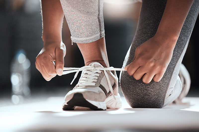 hansefit_krankenkassen_schrittwettbewerb Eine Person schnürt sich die Schuhe zum Laufen