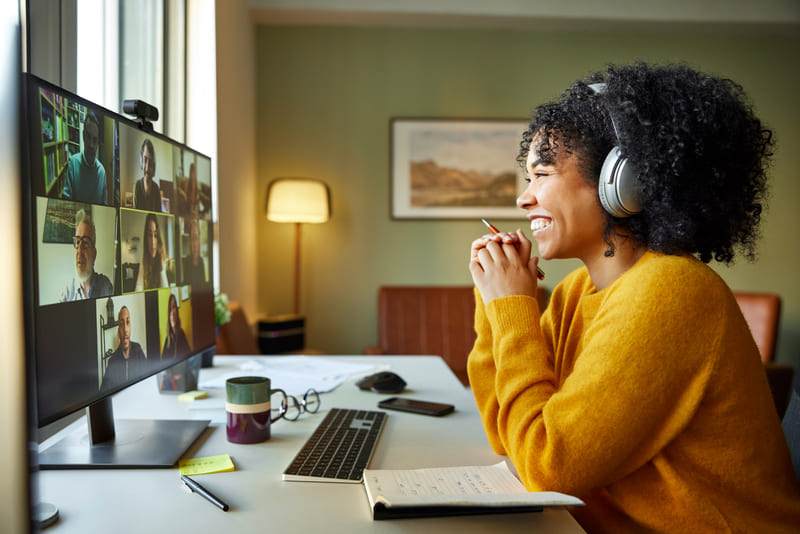 mitarbeitermotivation-bild3 Eine Frau sitzt mit Headset vor dem PC