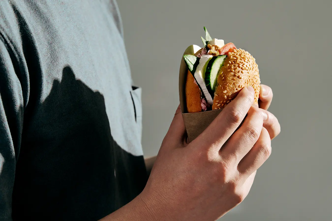 bagel Eine Person hat einen Bagel in der Hand.