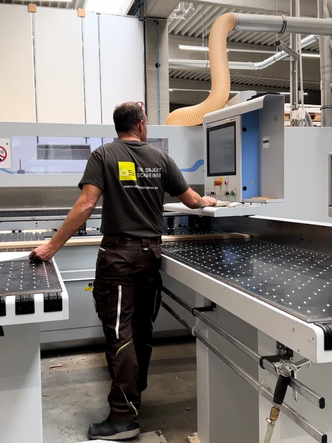 messebau-woernlein-10 Mann bedient eine CNC-Maschine in der Produktionshalle