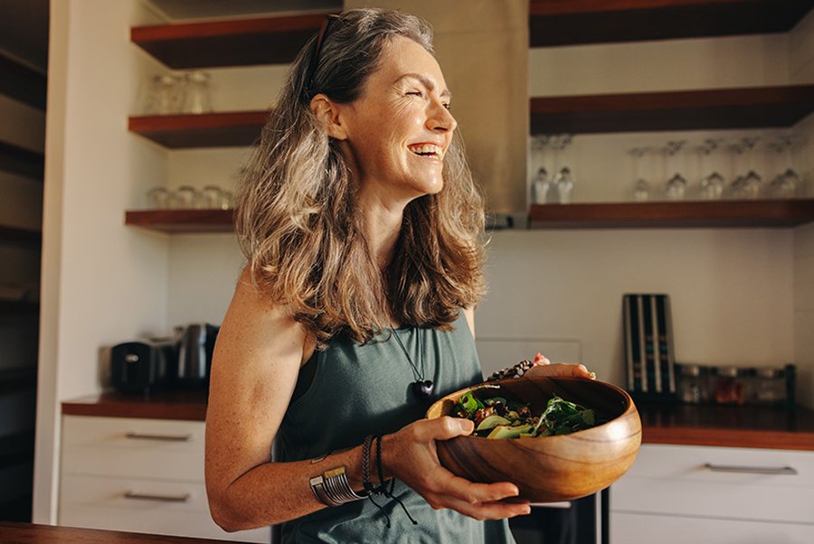header-gesunde-ernaehrung-im-alltag Eine Frau hält eine Schüssel mit Salat.