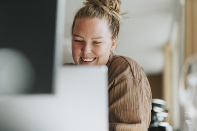 Happy female business professional working on laptop at office
