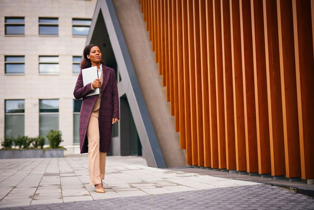 A woman in a purple coat walking to work.