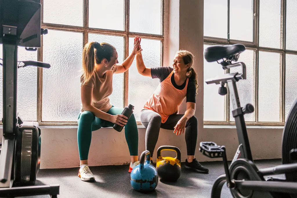 workout-fitnessstudio Zwei Frauen geben sich beim Workout im Fitnessstudio High Five